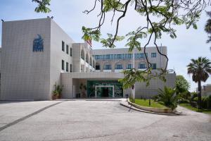 un edificio de oficinas con un estacionamiento delante de él en Leziria Parque Hotel, en Vila Franca de Xira