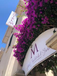 un cartel en un edificio con flores púrpuras en Hotel Chalet De L'isere, en Cannes