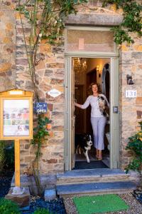 una mujer parada en una puerta con un perro en Le Jardin Des Secrets, en Namur