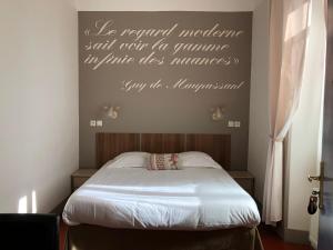 um quarto com uma cama com uma placa na parede em Hotel Chalet De L'isere em Cannes
