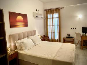 a bedroom with a large bed with white sheets at Asteri Hotel in Livadi