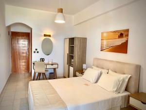 a bedroom with a large bed and a desk at Asteri Hotel in Livadi