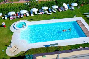 an overhead view of a swimming pool with people in the water at Enjoy Garda Hotel in Peschiera del Garda
