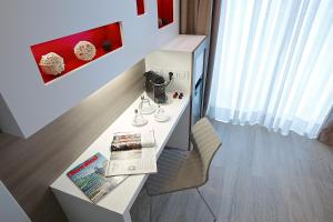 a room with a desk with a book and a chair at Enjoy Garda Hotel in Peschiera del Garda