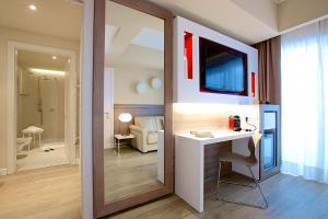 a bathroom with a sink and a desk in a room at Enjoy Garda Hotel in Peschiera del Garda