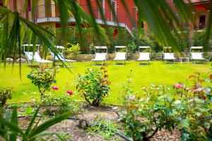 a group of chairs sitting in a garden at Enjoy Garda Hotel in Peschiera del Garda