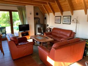 ein Wohnzimmer mit Ledermöbeln und einem TV in der Unterkunft Ferienhaus Anna in Dorum Neufeld