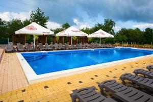 a large swimming pool with chairs and umbrellas at Оазис in Zalishchyky