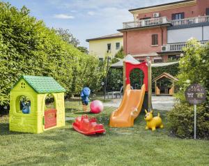 a group of childrens play equipment in the grass at Enjoy Garda Hotel in Peschiera del Garda