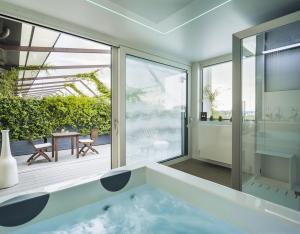 a bathroom with a bath tub and a patio at Enjoy Garda Hotel in Peschiera del Garda