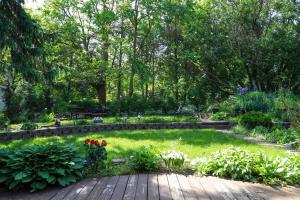 un jardín con un camino de madera, flores y árboles en Susan's Villa en Cataratas del Niágara