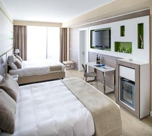 a hotel room with two beds and a television at Enjoy Garda Hotel in Peschiera del Garda