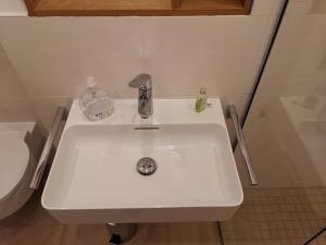 lavabo blanco en un baño junto a un aseo en Haus Antje, en Norddeich 8 fotos más