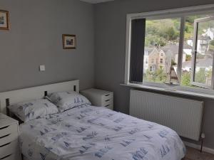 a bedroom with a bed and a large window at Admirals Apartment sleeps 4 adults 2 children EV Point in Looe