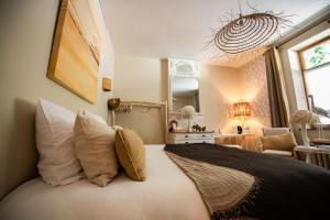 a bedroom with a bed with pillows on it at Le jardin des secrets in Namur