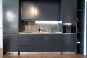 une cuisine avec des armoires bleu foncé et un évier dans l'établissement Anjos Balconies, à Lisbonne 109 autres photos