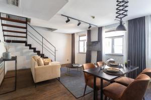 un salon avec une table et des chaises et un escalier dans l'établissement Anjos Balconies, à Lisbonne