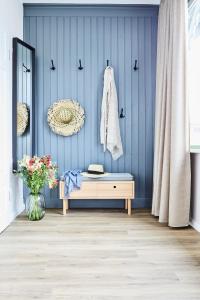Zimmer mit einer blauen Wand, einer Bank und einem Spiegel in der Unterkunft Villa Fortuna in Ostseebad Sellin