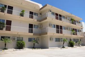 ein Apartmenthaus mit Palmen davor in der Unterkunft Hotel Mazatlan in Mazatlán