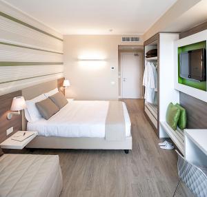 a hotel room with a bed and a flat screen tv at Enjoy Garda Hotel in Peschiera del Garda