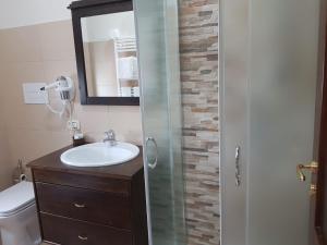 ein Bad mit einem Waschbecken und einer Glastür in der Unterkunft Affittacamere il Tuffatore in Paestum