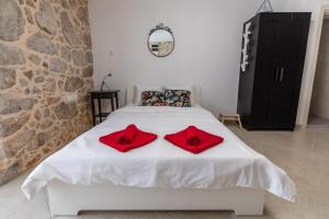 ein Schlafzimmer mit einem weißen Bett mit roten Kissen darauf in der Unterkunft Apartman Otto in Punat