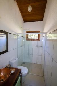 a bathroom with a toilet and a sink and a shower at Chale Escondidinho Serra do Cipo in Serra do Cipo