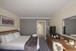 a hotel room with a bed and a flat screen tv at Holiday Inn Swindon, an IHG Hotel in Swindon