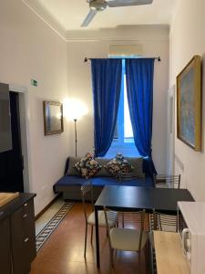 un soggiorno con divano blu e finestra di Otium Maecenatis Apartments a Roma