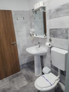 a bathroom with a white toilet and a sink at Vila La Matache in Eforie Nord