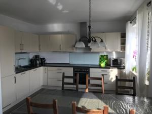 a kitchen with white cabinets and a table and chairs at Ferienhaus Nahe der Ostsee in Bad Doberan