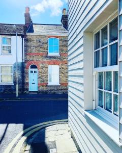 a brick house with a white door and a window at Prospect Cottage 5 mins walk to the beach in Deal