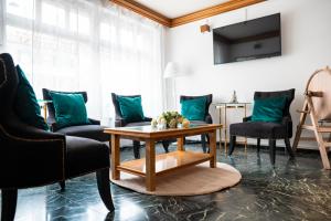 a living room with green chairs and a table at SWISS HOTEL LA COURONNE in Avenches