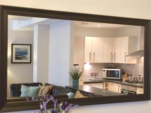a large mirror reflecting a living room and kitchen at Inverness City Suites in Inverness