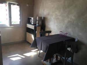 uma pequena cozinha com uma mesa e um micro-ondas em AUX PORTES D'AUBRAC studio 2 personnes em Salgues