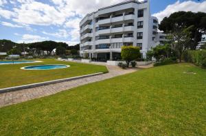 a building with a grassy yard next to a building at Tenis Golf Mar by OCvillas in Quarteira