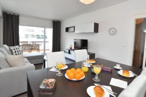 a living room with a table with oranges on it at Tenis Golf Mar by OCvillas in Quarteira