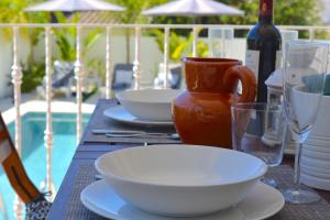 einen Tisch mit Teller und Schüsseln sowie eine Flasche Wein in der Unterkunft VILA CRISTINA MAR (8 guests and oceanview) in Albufeira