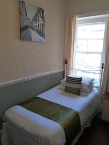 two beds in a room with a window at Ashfields in Llandudno
