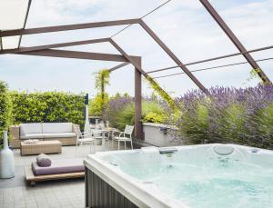 a jacuzzi tub in a garden with a patio at Enjoy Garda Hotel in Peschiera del Garda