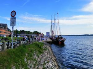 eine Gruppe von Booten, die an einem Dock auf einem Wasserkörper angedockt sind in der Unterkunft Backstage Apartment Kiel-Holtenau in Kiel