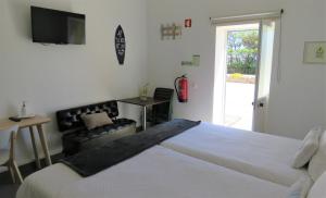 A bed or beds in a room at Sagres Relax Studios