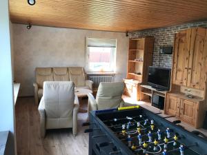 a living room with a foosball table in front of a living room at Biker's Base Baddeckenstedt in Baddeckenstedt