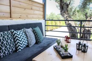 eine blaue Couch auf einer Veranda mit Kissen in der Unterkunft Vabel Skiathos in Skiathos-Stadt