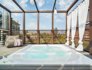 a hot tub on a deck with a large window at Enjoy Garda Hotel in Peschiera del Garda