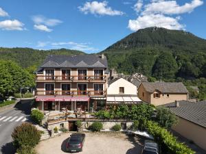 un hotel con una montaña en el fondo en Le Vallon, en Ispagnac