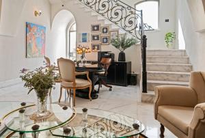 ein Wohnzimmer mit einem Glastisch und Stühlen in der Unterkunft Casa Nova - Luxury Suites & Boutique Apart-Hotel in Tel Aviv