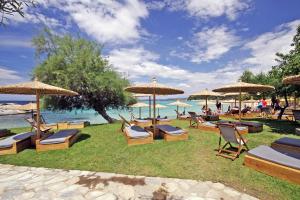 eine Gruppe von Stühlen und Sonnenschirmen am Strand in der Unterkunft Akti Kalogria Hotel in Kalogria