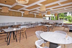 ein Restaurant mit Tischen und Stühlen in einem Raum in der Unterkunft Akti Kalogria Hotel in Kalogria