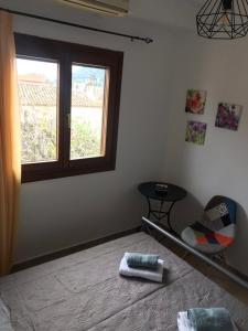 a bedroom with a bed and a window and a chair at Colorful house in Kriopigi in Kriopigi